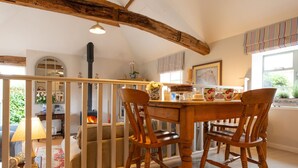 A dining area with a wooden table and chairs, a fireplace, and a view of the outdoors. - The Stables -  A rural, romantic retreat in a particularly pretty countryside setting close to Castl (Great Maplestead)