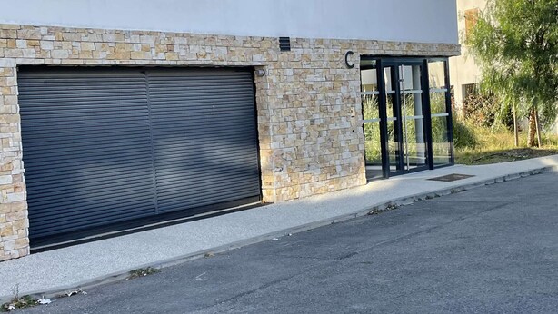 En moderne bygning med en garageport og en stenfacade.