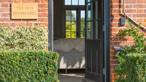 A wooden sign reading "The Old Steammill" mounted on a brick wall. - Five Star style with beautiful views of idyllic Countryside: The Old Steam Mill (Hartest)