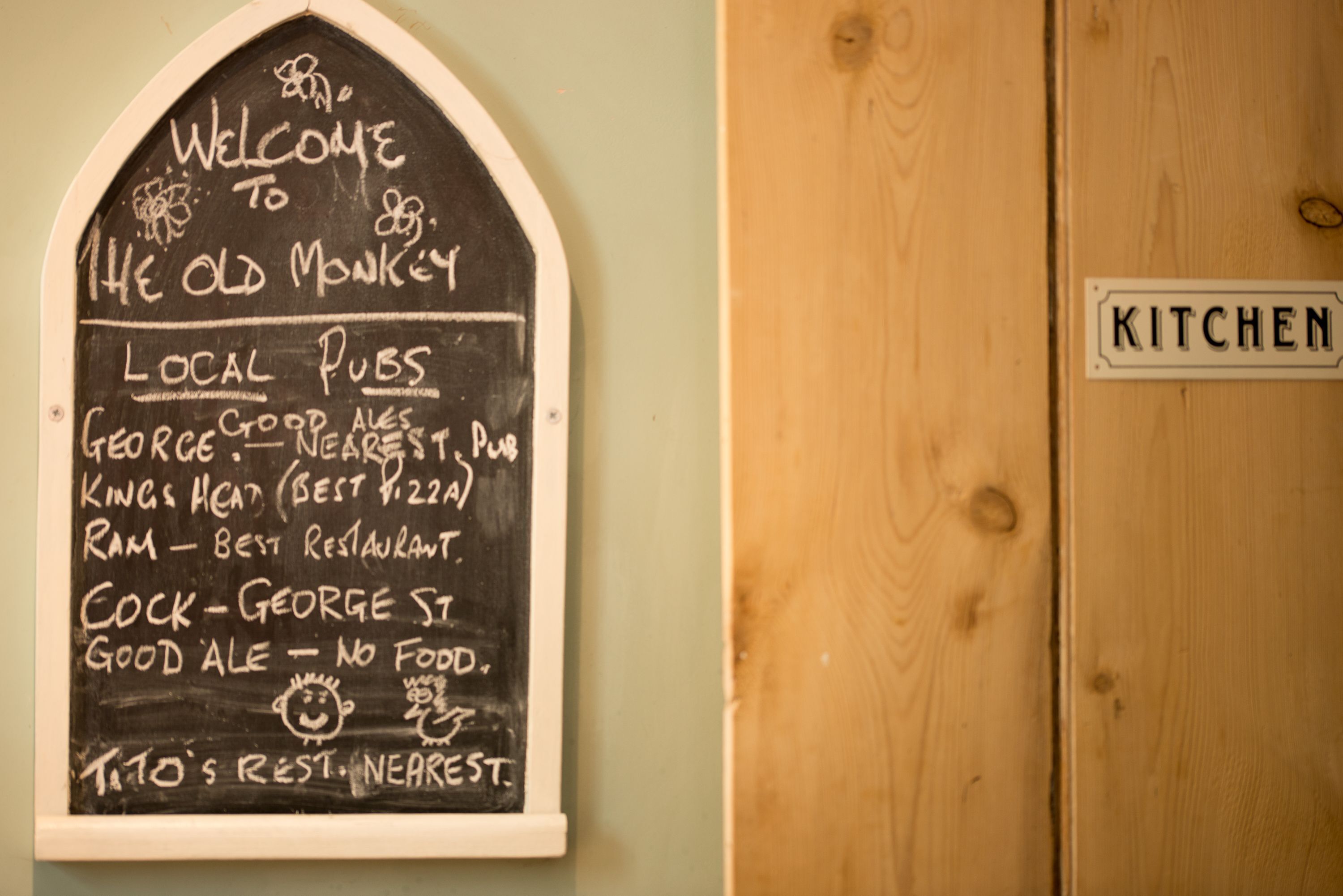 A chalkboard sign with a welcome message and a list of local pubs and restaurants.