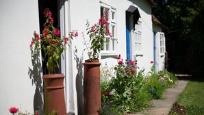 A white house with a garden, a pathway, and a window with blue shutters. - Remote, Comfort, Sea Views, and the romance of the beautiful Essex Marshes - The Wobbin (Tollesbury)
