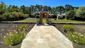 A pathway leading to a wooden structure with a door, surrounded by landscaped gardens and trees. - Beautiful contemporary villa, swimming pool and large garden (Berre-l'Étang)