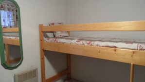 A bunk bed with a mirror on the wall, a radiator below, and patterned bedding. - Studio cabin for 4 near slopes, Southwest exposure in Chamrousse (Chamrousse)
