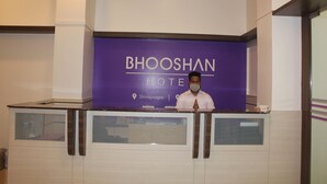 Eine Rezeption mit einem Schild für das BhooShan Hotel in Shivalnagar.