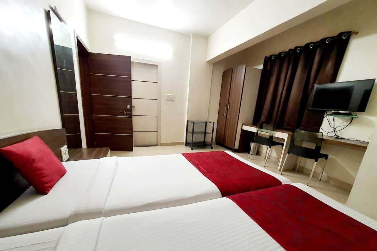 Ein Hotelzimmer mit Bett, Schreibtisch, Fernseher und Kleiderschrank.