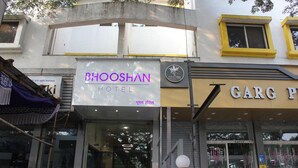Ein Hotel namens 'Bhooshan Hotel' mit einem Schild davor.