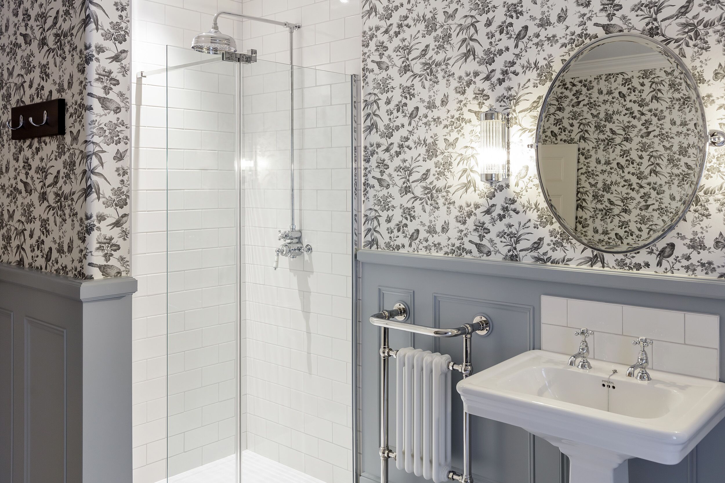 A bathroom with a shower, a sink, and a mirror.