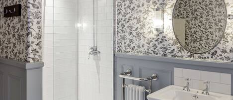 A bathroom with a shower, a sink, and a mirror.