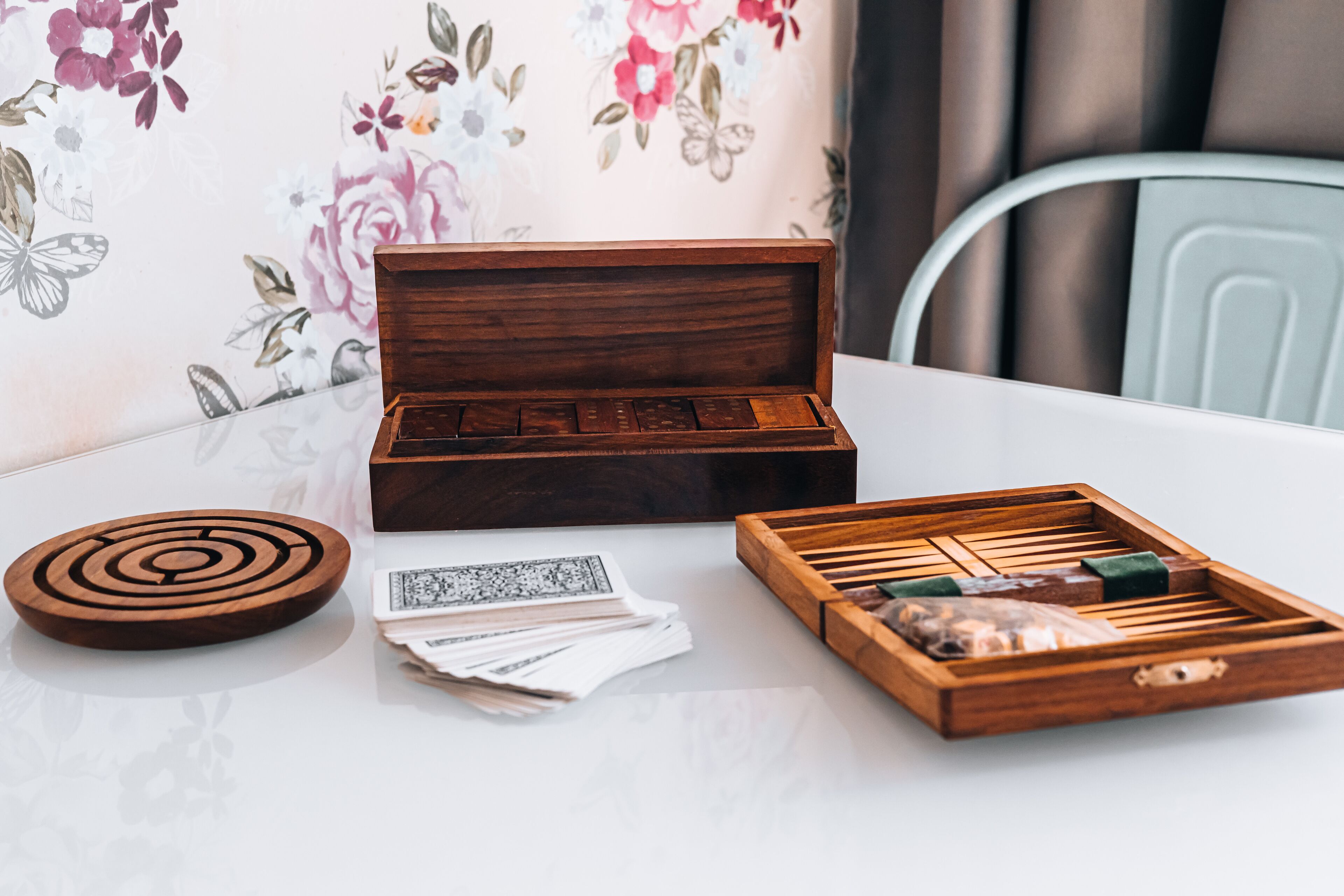 Una caja de madera con compartimentos, una bandeja circular y una bandeja rectangular también con compartimentos sobre una mesa.