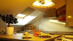 A modern kitchen with a wooden island, white chairs, and a unique pendant light. - Luxury penthouse in the centre of Lerma (Lerma)