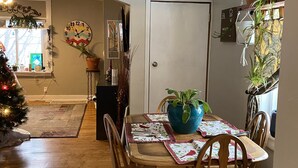 A dining area with a wooden table, chairs, and a blue vase with a plant. - Built in 1866 this hillside home is close to everything! (Duluth)