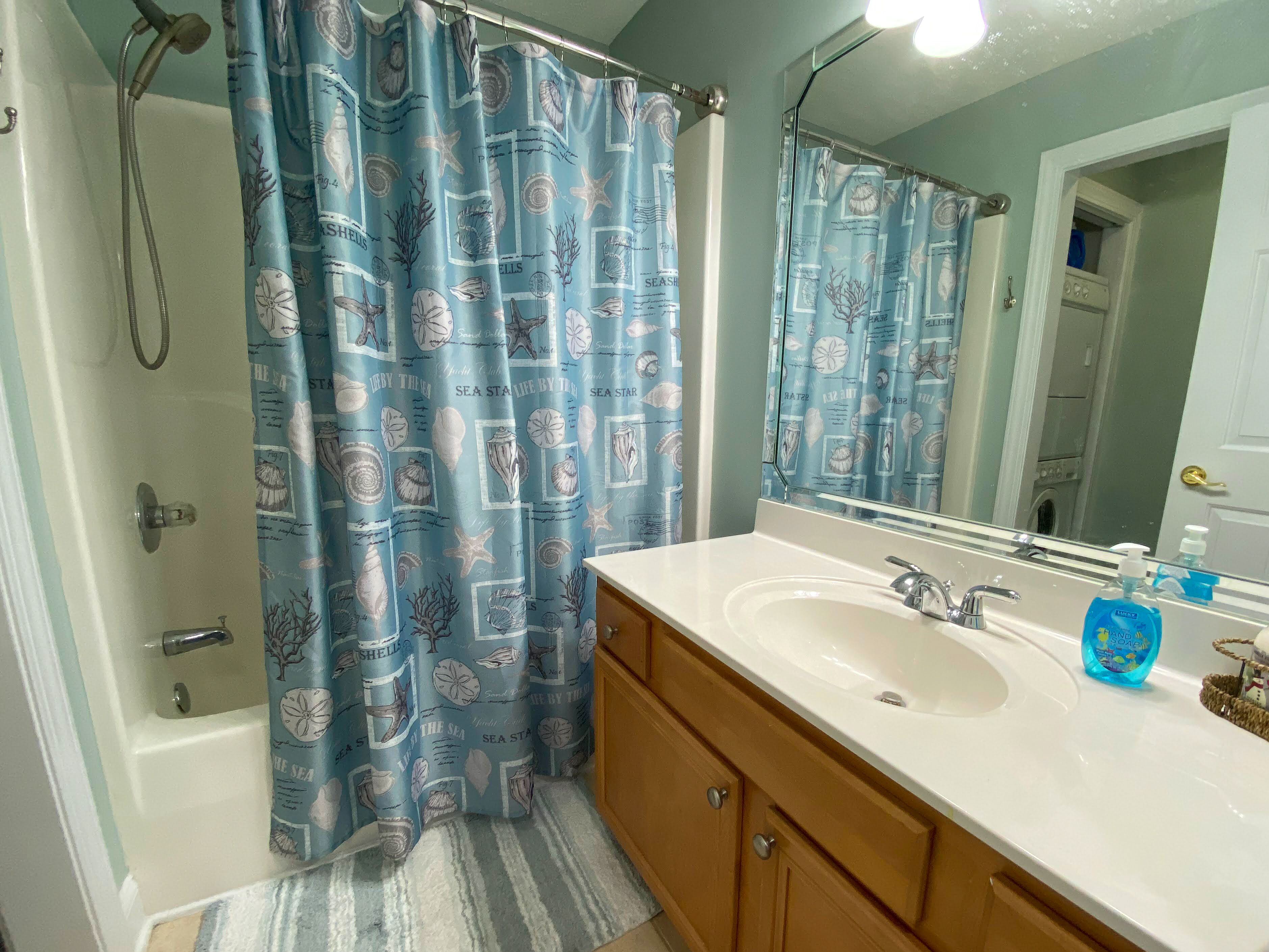 Une salle de bain avec une baignoire, une douche, un lavabo et un miroir.