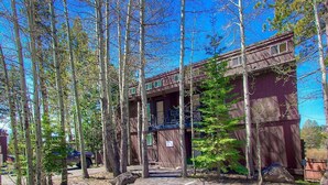 A rustic wooden building surrounded by tall trees, with a clear sky above. - Park View Paradise | BBQ | Summer Pool & Tennis (Tahoe City)