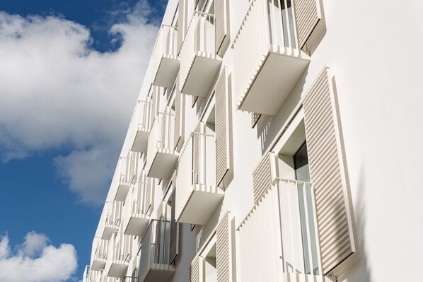 Un edificio de varios pisos con balcones y ventanas amplias.