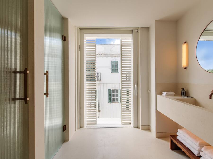 Un baño moderno con un espejo grande, un lavabo y un perchero para toallas.