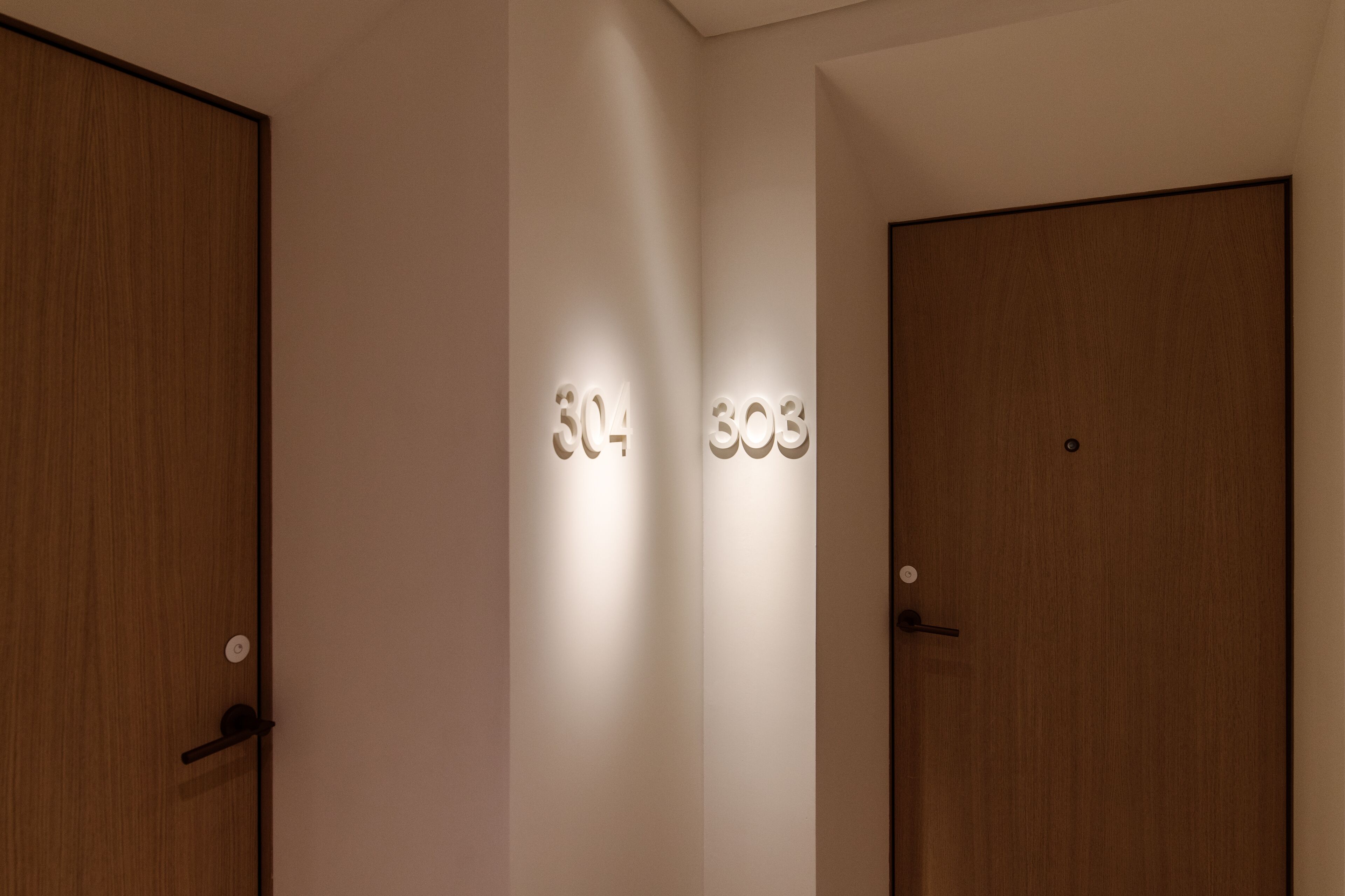 Une chambre d’hôtel avec deux portes, chacune portant un numéro.