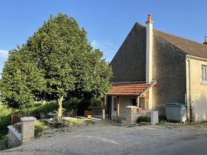 A house with a large tree in front, a gravel driveway, and a small porch. - Large bright house with panoramic view (Saizy)
