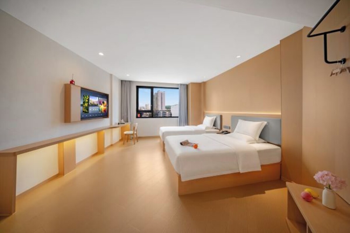 A modern hotel room with a large bed, a desk, and a television.