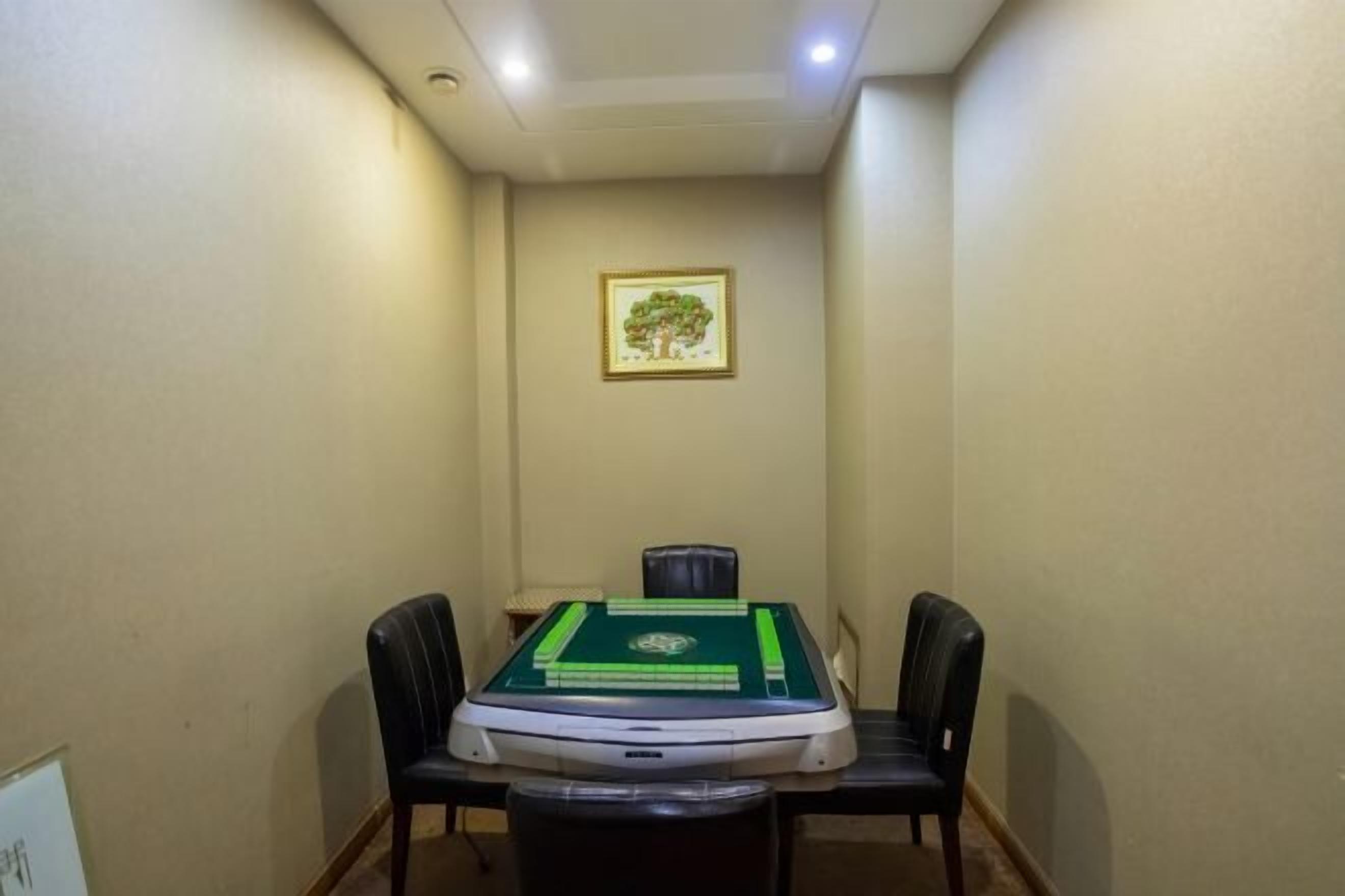 Un pasillo estrecho con una mesa y sillas, un cuadro en la pared y una lámpara en el techo.