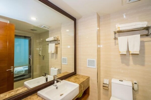 A modern bathroom with two sinks, a large mirror, and a glass shower enclosure. - Dahua Boutique Hotel Harbin Exhibition Center (Harbin)