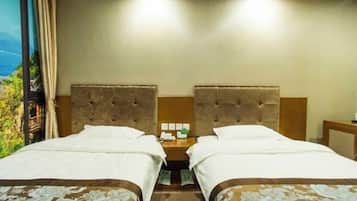 A hotel room with two beds, a nightstand, and a view of greenery.