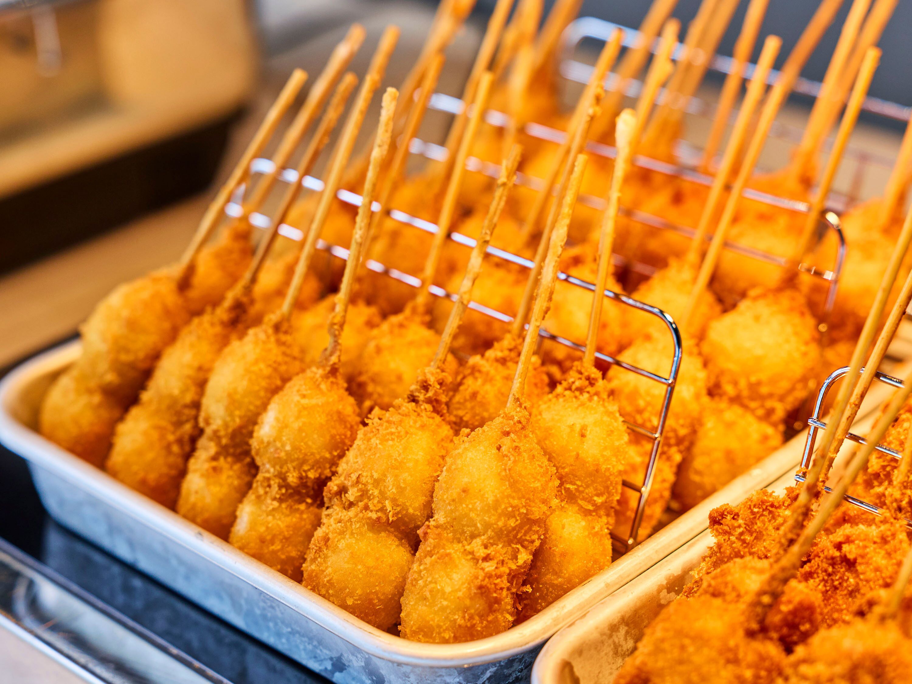A safata d'aliments fregits, probablement un aperitiu o postre, col·locada sobre una graella de metall.