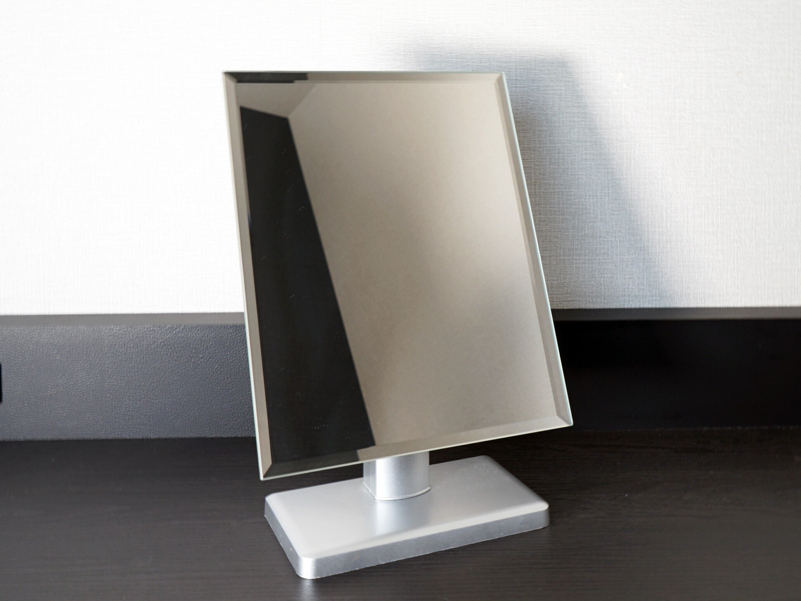 A modern, minimalist desk lamp with a rectangular base and a sleek, metallic shade.