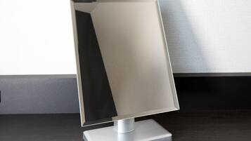 A modern, minimalist desk lamp with a rectangular base and a sleek, metallic shade.