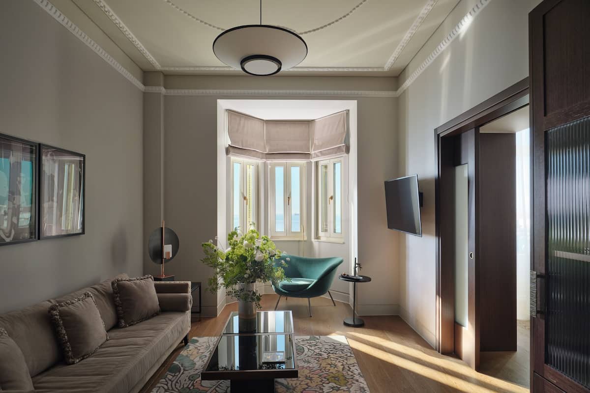 A living room with a sofa, a coffee table, a TV, and a view of the outside.