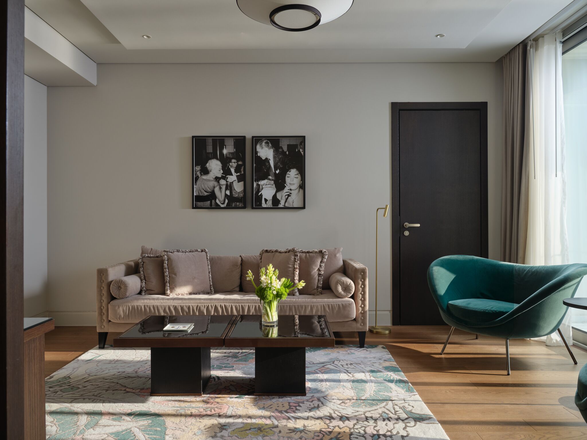 Ein modernes Wohnzimmer mit einer Couch, einem Couchtisch, einem Sessel und zwei gerahmten Bildern an der Wand.