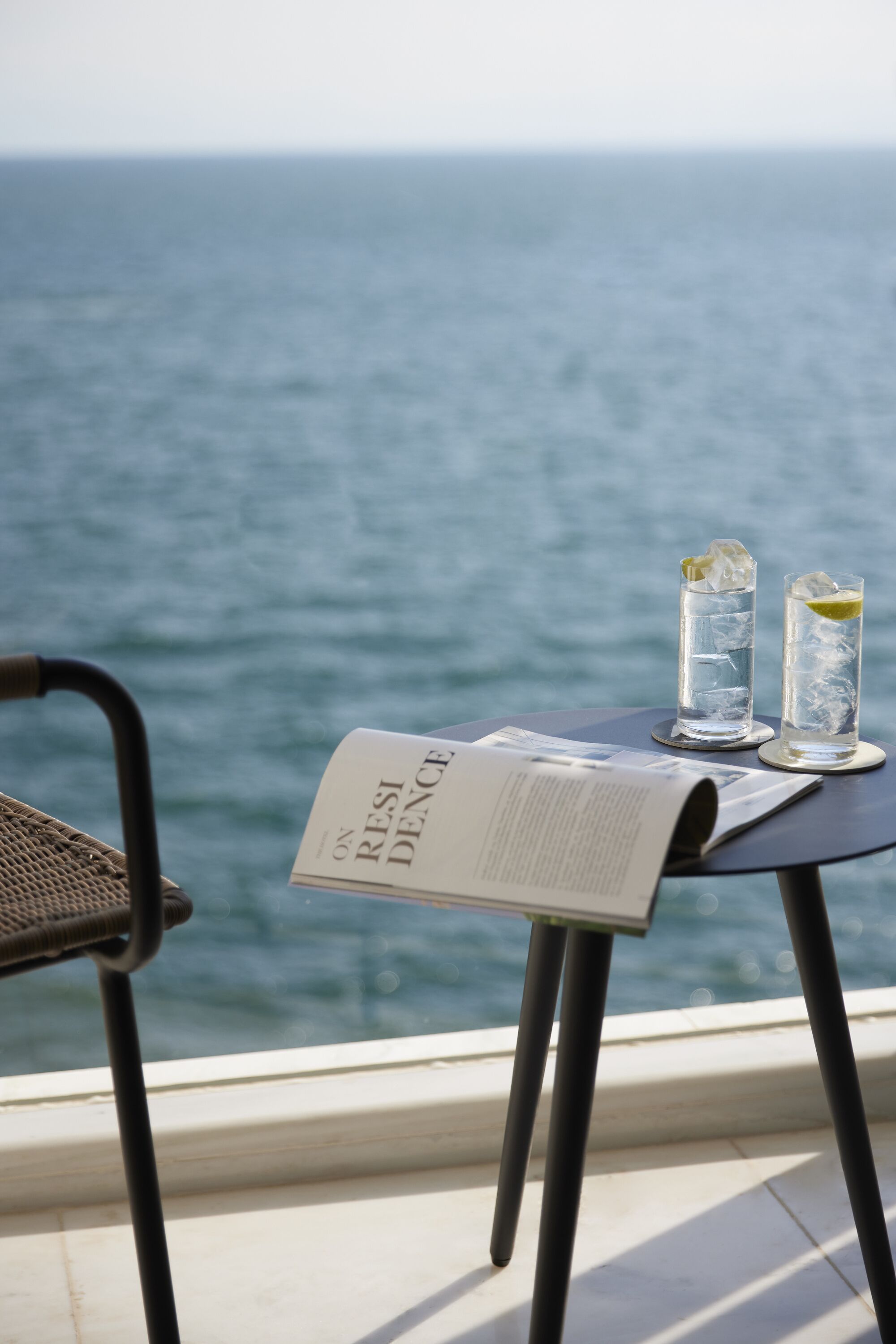 A table with two glasses of water and a menu, overlooking a body of water.