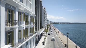 A waterfront hotel with balconies, a pedestrian walkway, and a view of the water.