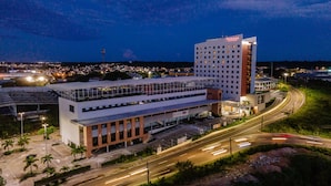 A modern hotel with a prominent "RAMADA" sign, featuring a rooftop terrace and a parking area. - Ramada by Wyndham Manaus Torres Center (Manaus)
