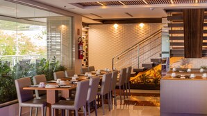 A modern dining area with a long table, chairs, and a coffee station. - Ramada by Wyndham Manaus Torres Center (Manaus)