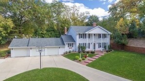 A two-story house with a front porch, a garage, and a well-maintained lawn.
