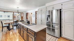 A modern kitchen with stainless steel appliances, wooden cabinets, and a central island.