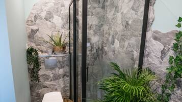 Een douche, handdoeken, zeep, toiletpapier