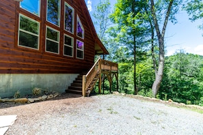 Eine Holzhütte mit einer Holztreppe, die zu einer Veranda führt.