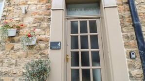 A building facade with a stone wall, a door labeled "JIPPER HOUSE," and a sign indicating "HURGILL ROAD." - Jaipur House (Richmond)