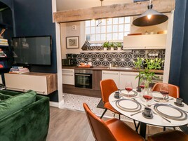 Cocina moderna con comedor, que presenta una mesa redonda preparada para dos personas, con copas de vino y platos.