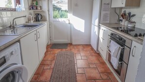 Una cocina funcional con lavadora, microondas y horno.