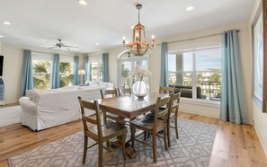 A spacious living area with a dining table, chairs, and a sofa.