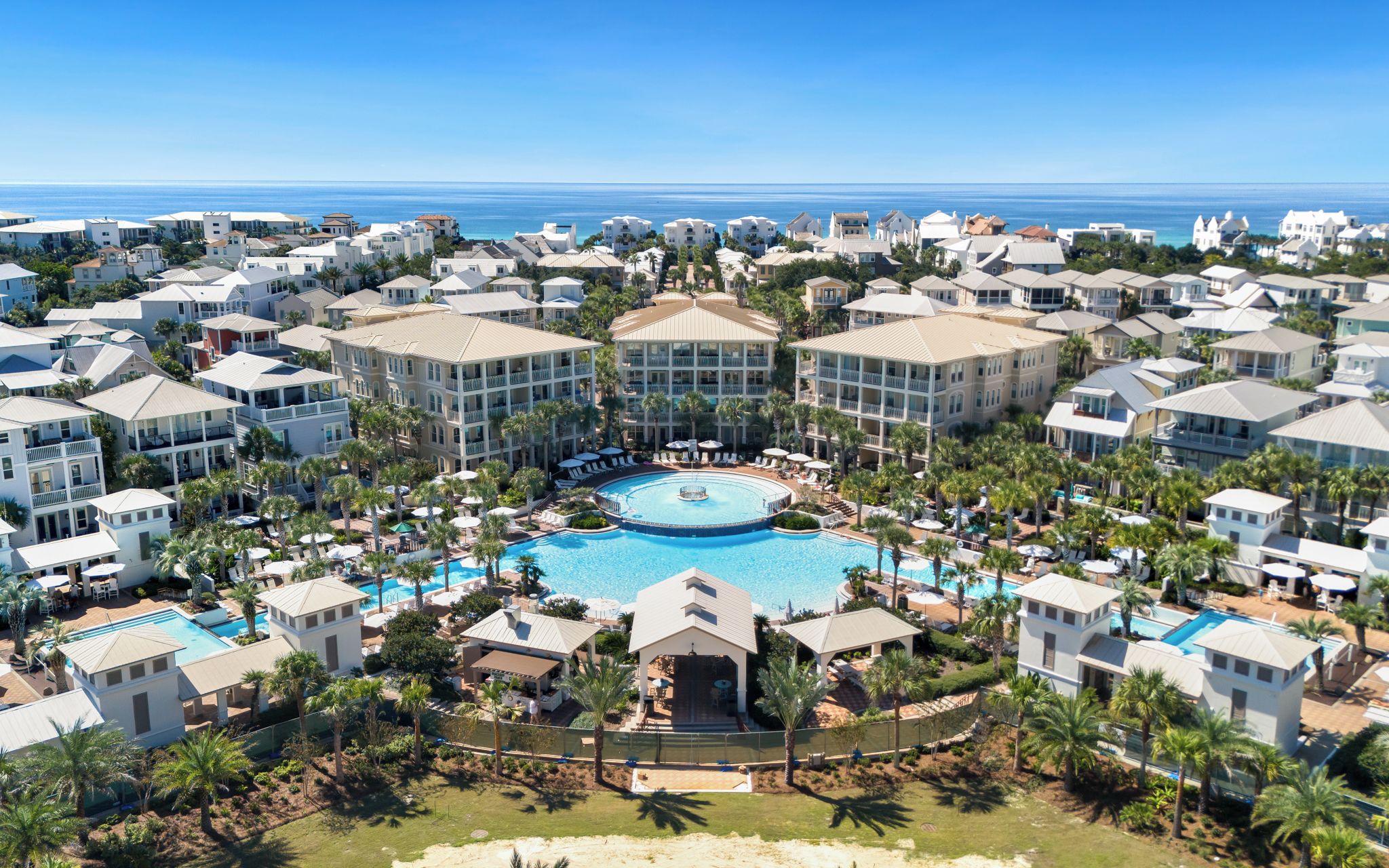 Ein Resort mit mehreren Gebäuden, einem zentralen Pool und Blick auf den Ozean.