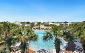 A resort with a central swimming pool surrounded by palm trees and lounge chairs. - New Rental in Seacrest Beach Resort, stunning views of Lagoon Pool, 3 bikes! (Panama City Beach)