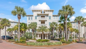 A large, multi-story hotel with a symmetrical facade, featuring balconies and a central entrance. - New Rental in Seacrest Beach Resort, stunning views of Lagoon Pool, 3 bikes! (Panama City Beach)
