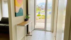 Un saló modern amb un sofà, una taula consola i un quadre.