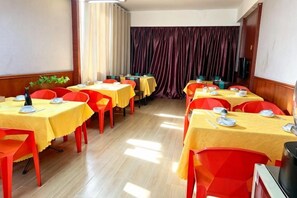 A dining area with multiple tables and chairs, arranged in rows, with a curtain in the background. - Forbes Hotel (Shenzhen Longhua Dalang Commercial Center) (Shenzhen)