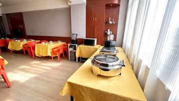 A room with tables and chairs, a coffee machine, and a jukebox.