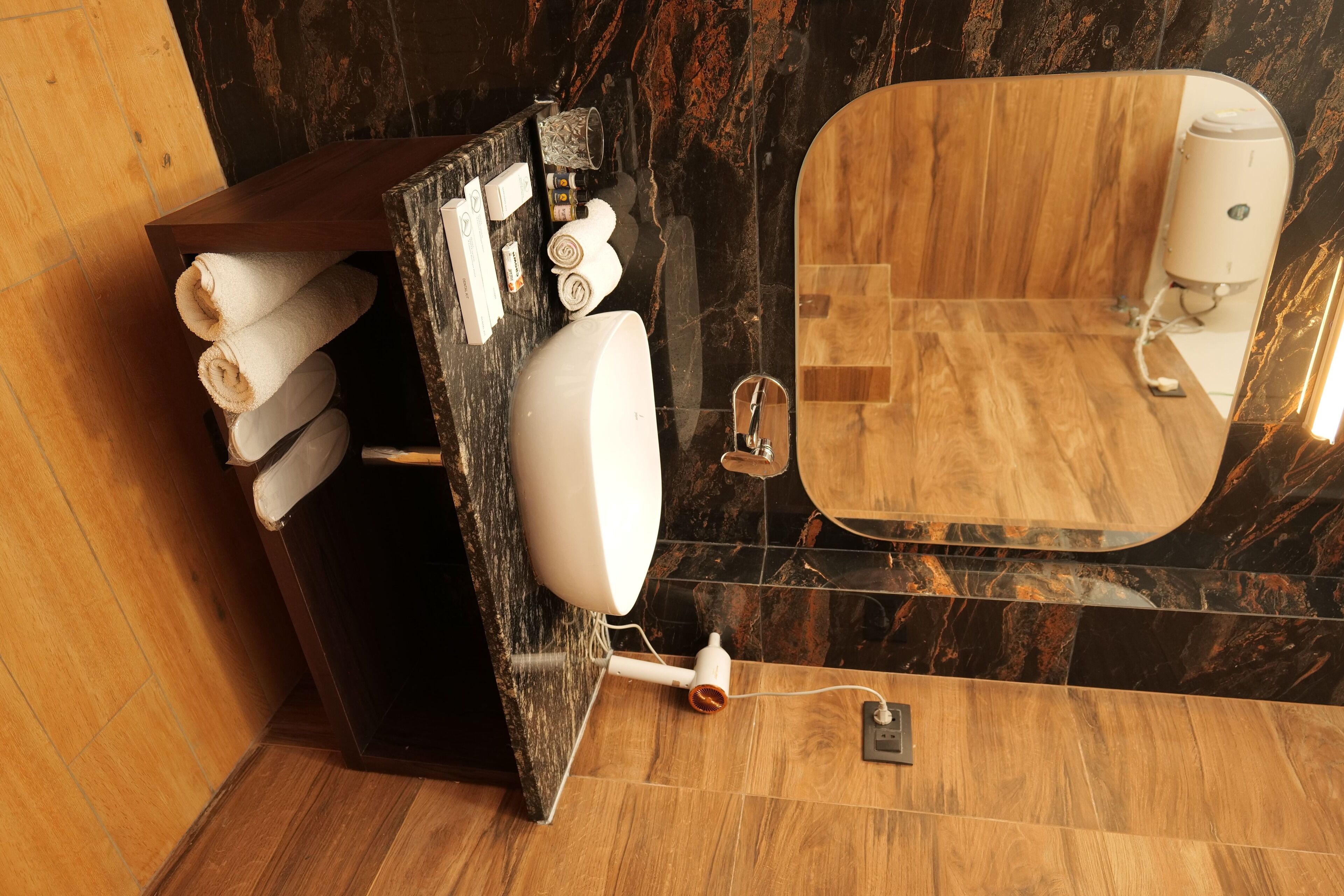 Une salle de bain avec un meuble-lavabo en bois, un grand miroir et un porte-serviettes.
