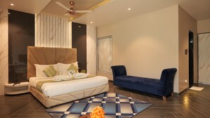 A modern bedroom with a large bed, a blue sofa, and a patterned rug. - Hotel 777, Pushkar (Pushkar)